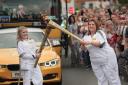 Two of the torch runners pass the flame in Bicester today