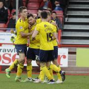 Chris Maguire is mobbed after scoring Oxford United's equaliser  Picture; David Fleming