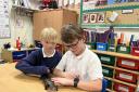 Two Wootton St Peter’s CE Primary School pupils with a lizard