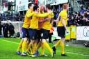 James Constable (centre) is surrounded by his Oxford United teammates after firing the U’s ahead