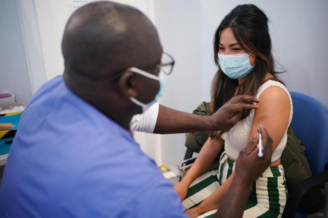 Kyna Bigornia receives her Pfizer Covid-19 booster injection at a vaccination site in Liberty Shopping Centre, Romford, east London, as the Government accelerates the Covid booster programme to help slow down the spread of the new Omicron variant (Yui