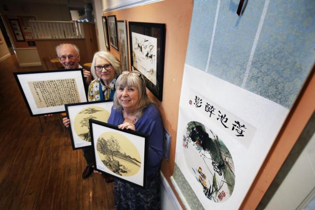 Herald Series: They are standing next to a scroll donated by a Chinese artist, Mrs Zhen, 79, who painted the artwork during covid and has donated the scroll to the Group. It will be raffled to raise funds. 