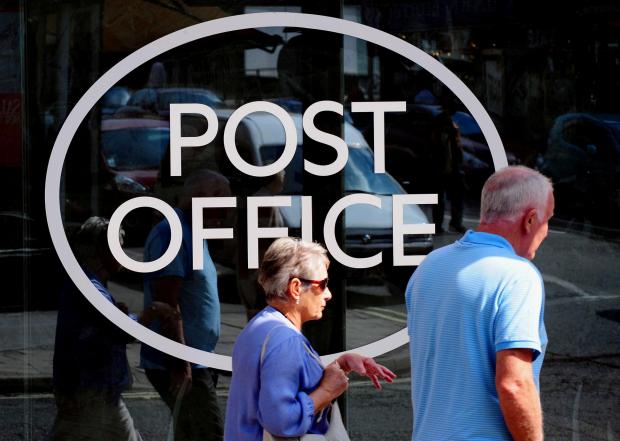 Herald Series: People walking outside a Post Office. Credit: PA