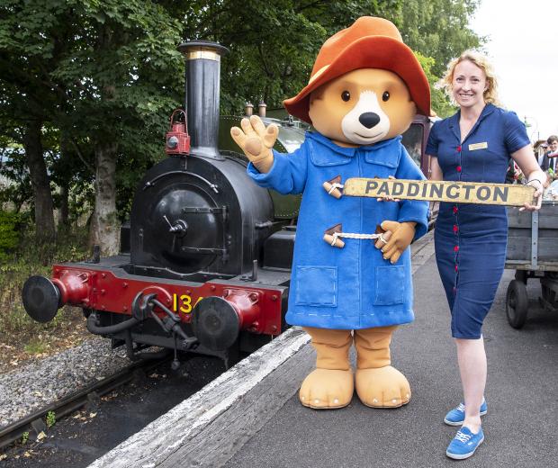 Herald Series: Paddington with Chrissy Crisp of the railway centre’s visitor services team and locomotive No 1340 Trojan. Chrissy is holding an original train destination board lettered Paddington, from Didcot's museum collection. Picture by Frank Dumbleton