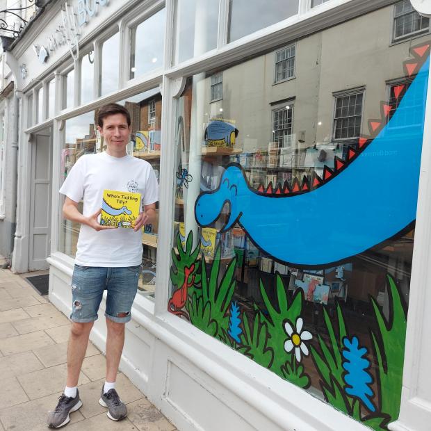 Herald Series: Rob Jones outside Mostly Books, Abingdon, holding his third children's book