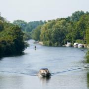 A boat is driven along the river Thames in Wallingford