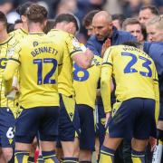 Oxford United players take on drinks and instructions during a break in play
